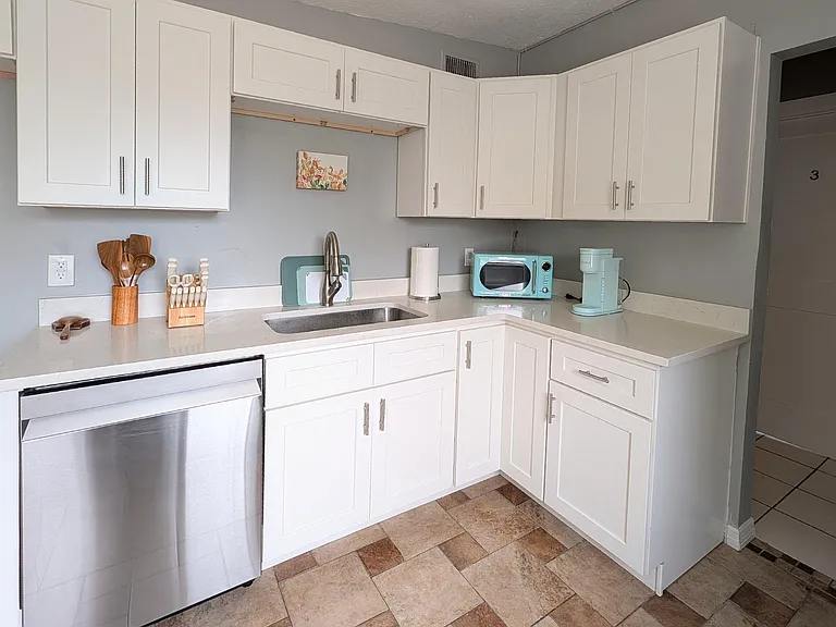 Efficient kitchen with shaker cabinetry, ample counter space, and a single-basin sink for easy meal prep and cleanup.