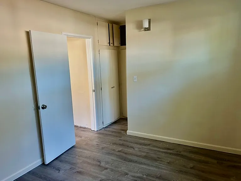 Bedroom looking toward bathroom hall and living room door.