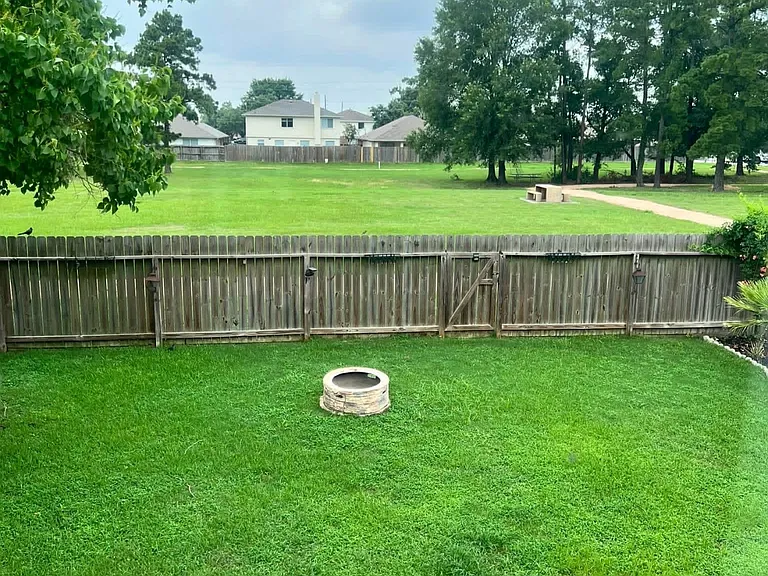 Fire pit and view of gate leading to walking trails, and park behind home.