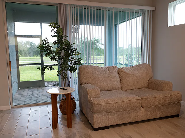 Covered Lanai, accessible from Living Room. Includes Floor- to- Ceiling double sided Sliding Glass doors.