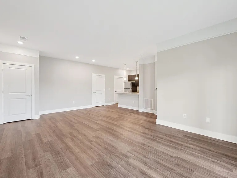 Dooley's Orchard unit showing a living room with wooden flooring and white walls.