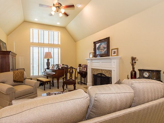 Formal living room has high ceiling, fireplace and tall windows