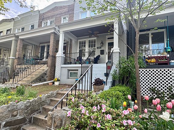 Front of house features a new handrail, a flower/ivy garden, hose access, a ceiling fan, and a recently painted porch.