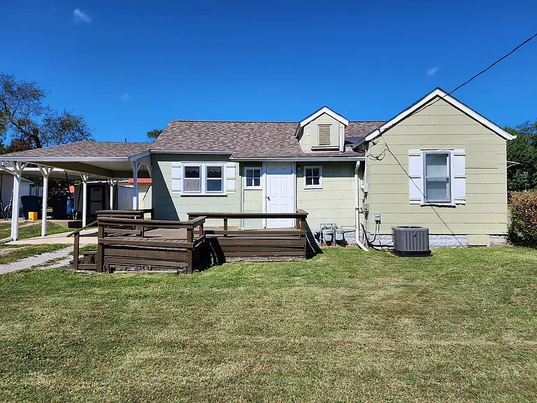 Back/side of house. Deck leading into laundry and furnace room. Then a 2nd door leading into dining room.