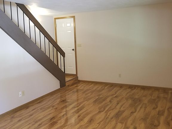 Living Room area with hardwood floors (18'7" x 13'10"). Door leads to garage