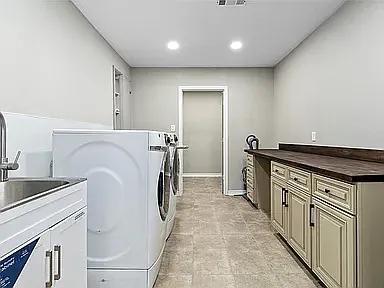 Large utility Room off of kitchen with mop sink and craft area, plus a storage closet. W/D not provided