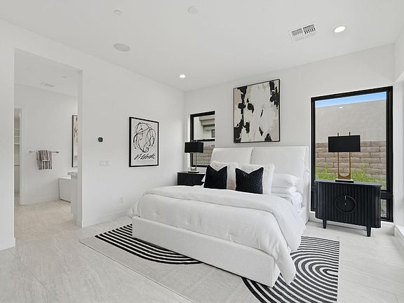 Expansive primary bedroom with luxurious bright white finishes