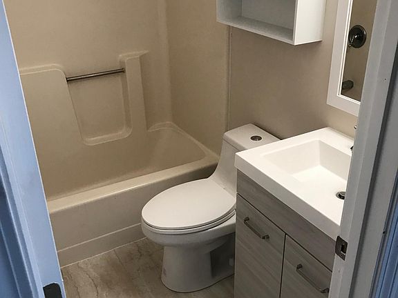 Updated bathroom with new vanity, dual flush toilet, cabinet, lighting and flooring