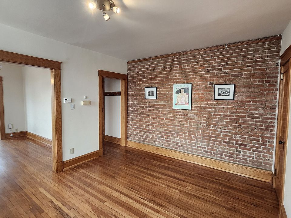 Dining room with exposed brick, living room and sunroom with office.