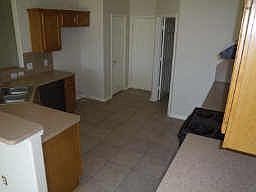 tiled floors, black appliances, and stainless steel sink in the kitchen