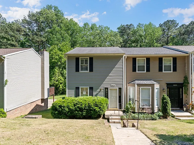 Welcome to 4829 Fulmar Drive _ charming end-unit townhome with classic exterior and mature landscaping