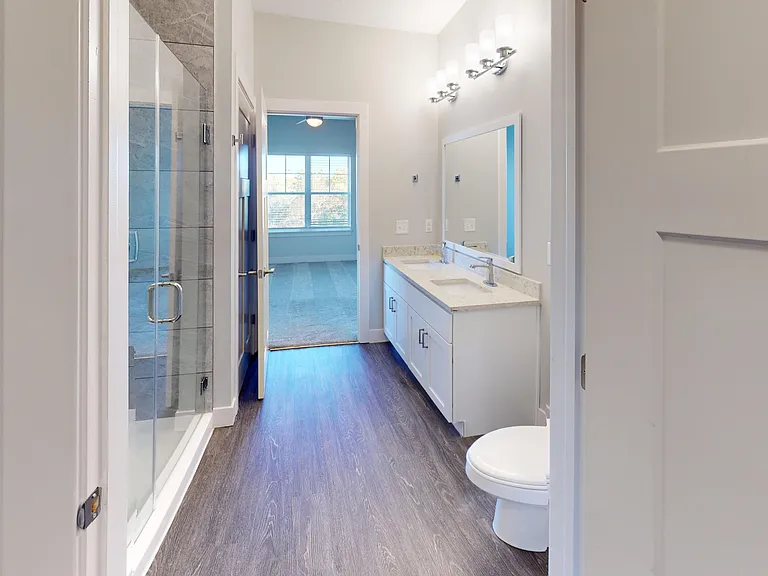 The Dogwood primary en suite bathroom features a double sink vanity and standing shower with a glass door. The Dogwood primary en suite bathroom features a double sink vanity and standing shower with a glass door.