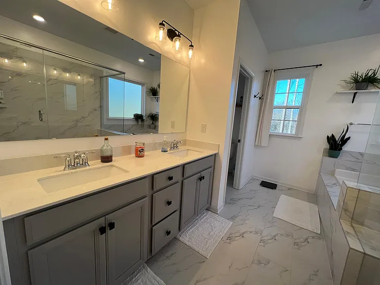 Primary private luxurious bath with dual vanities, quartz countertops, tile flooring, private water closet....
