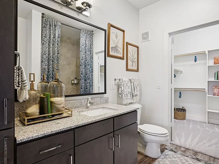 Bath with espresso cabinetry, speckled granite countertops, and hard surface flooring