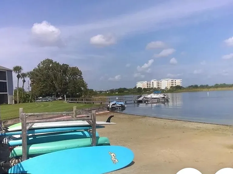 Beach area with dock for boats in the back.
