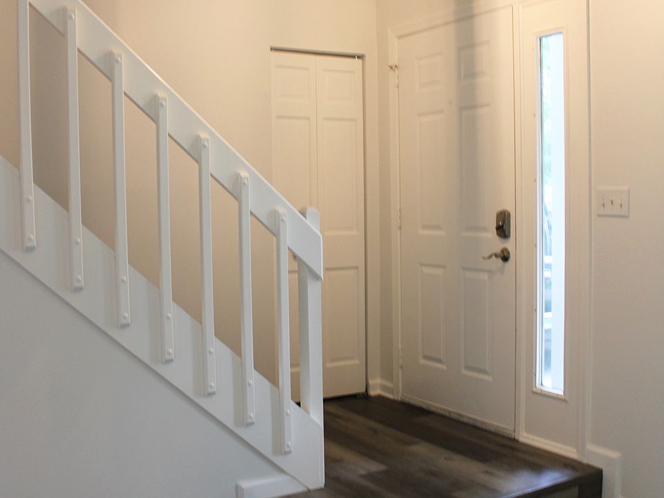 Foyer to living room area with coat closet, keyless entry and new light fixture
