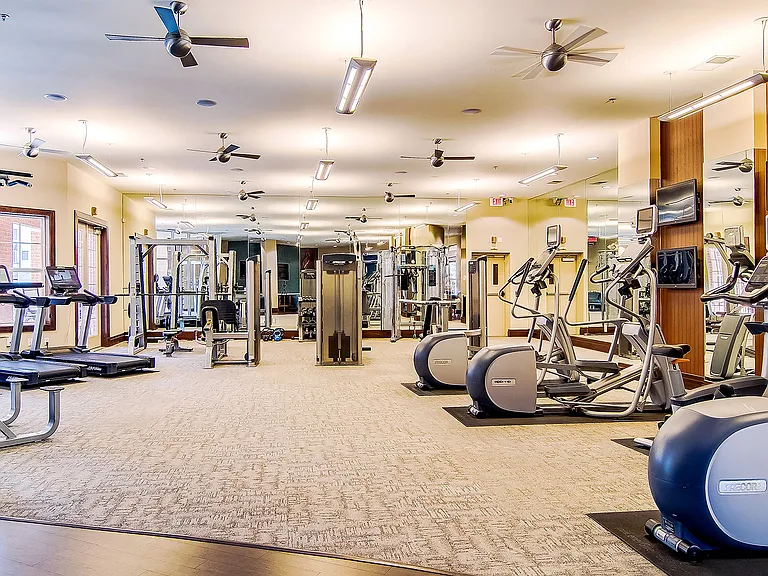 Expansive Fitness Center with Interactive TV Monitors Overlooking Pool