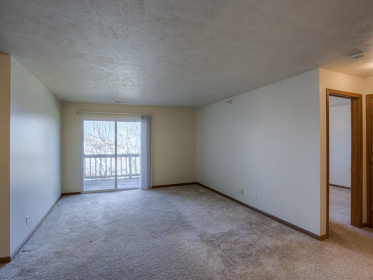 Living room with sliding glass doors to balcony at Huntington Apartments.