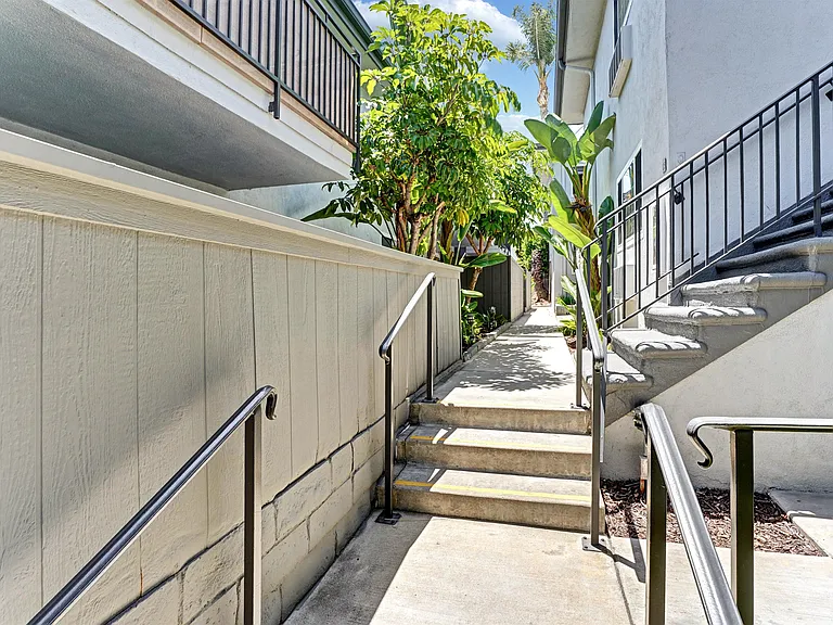 A staircase with a metal railing leads up to a building