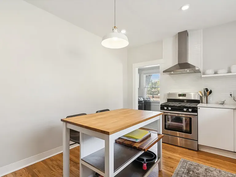 Kitchen with view leading into laundry room, which now has a swinging door installed