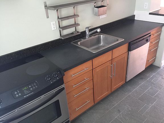 Modern kitchen with premium stainless appliances and natural slate floor.