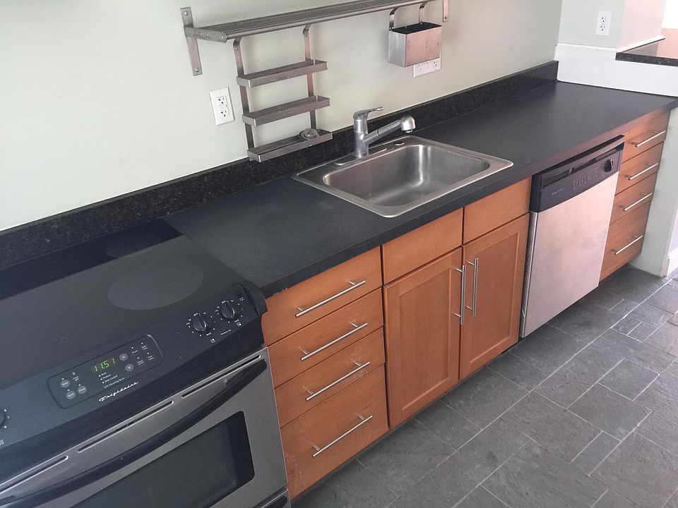 Modern kitchen with premium stainless appliances and natural slate floor.