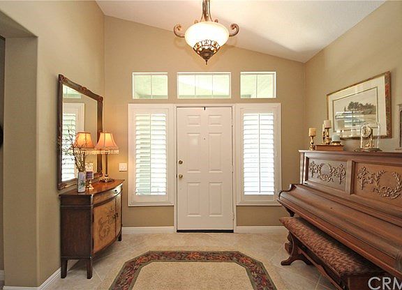 Spacious foyer with a vaulted ceiling, plantation shutters and upgraded light fixture