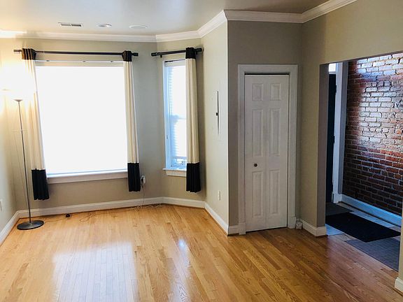 Living room with hardwood floors, ceiling speakers and recessed lighting. Coat closet.