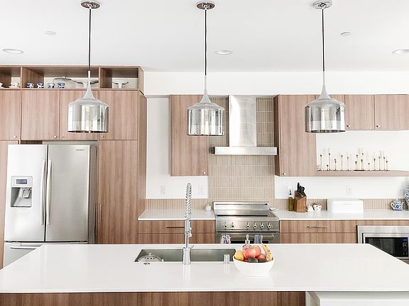 Kitchen has premium Bertazzoni induction stove and dishwasher, Samsung refrigerator, and large quartz countertops.