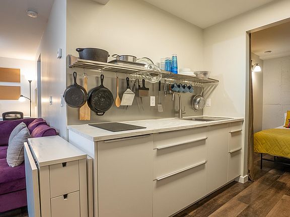 Kitchenette has a built in induction hotplate, sink, microwave, and fridge.