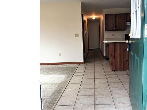 Walk in the back door to easy to maintain tile flooring and berber carpet.