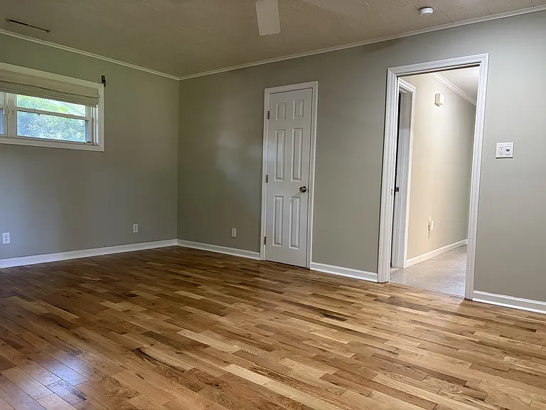 Spacious primary bedroom featuring beautiful hardwood floors, generous closet space, and direct access to the private en-suite bathroom.
