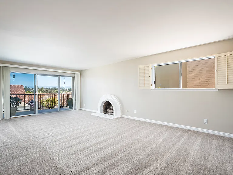 Living area with gas fireplace and sliding door to private balcony/patio.