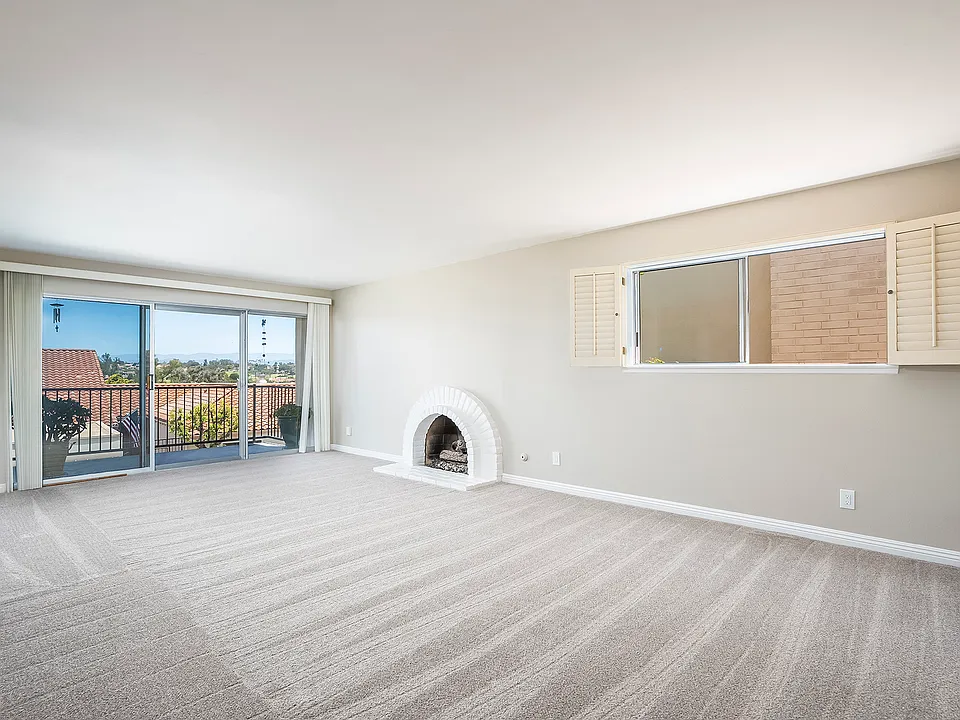Living area with gas fireplace and sliding door to private balcony/patio.