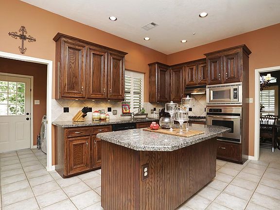 The large chef's kitchen is equipped with custom cabinetry, stainless appliances and a gas cooktop. 