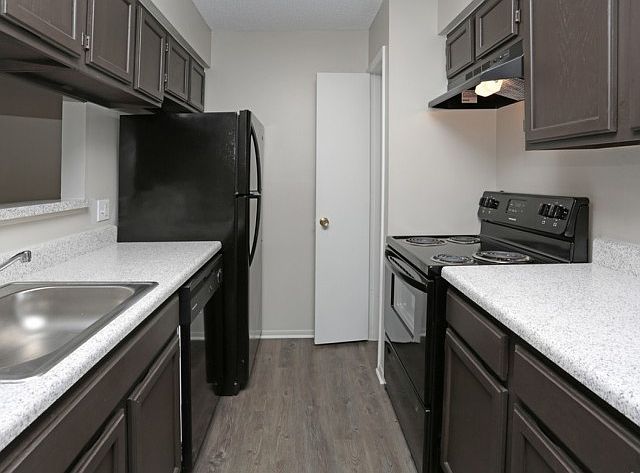 Enjoy a fully equipped kitchen with dark espresso cabinetry, granite-style countertops, and modern black appliances_perfect for daily cooking or hosting. ___ Alt Text: