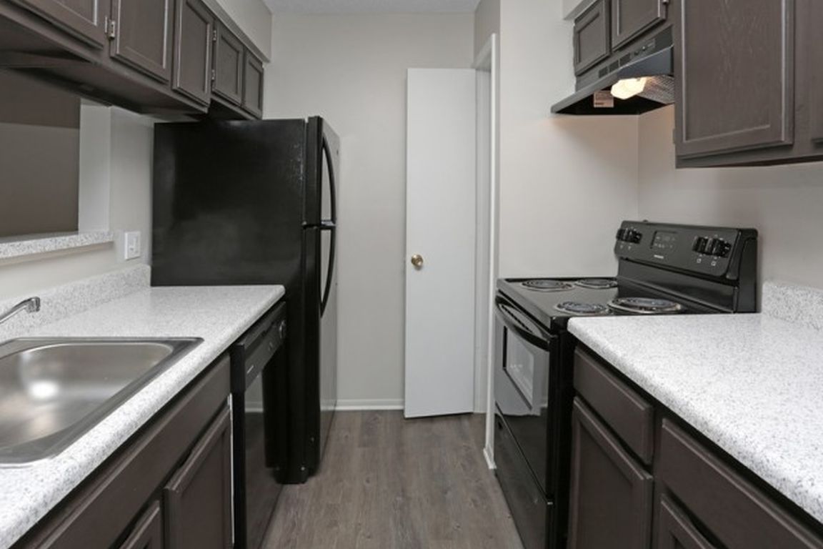 Enjoy a fully equipped kitchen with dark espresso cabinetry, granite-style countertops, and modern black appliances_perfect for daily cooking or hosting. ___ Alt Text: