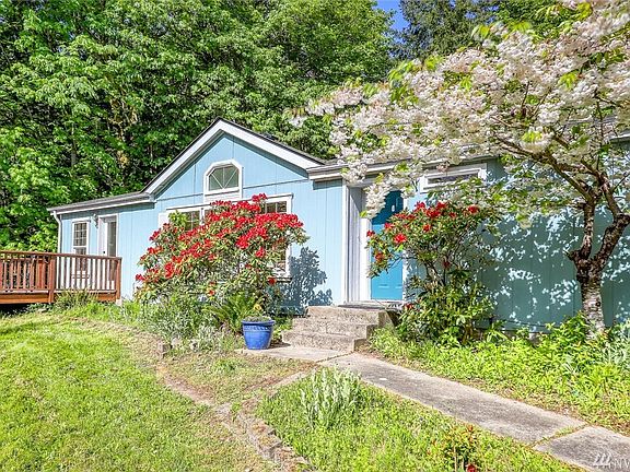 Flowering shrubs and tree frames the entry walkway. 