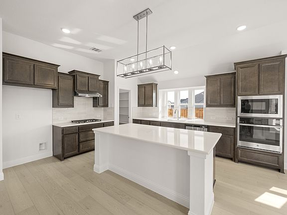 Sandstone II floor plan featuring a main-level primary suite, open-concept living, private study, an