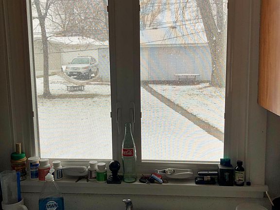 View of backyard from kitchen (this unit comes with 1 car garage and carport on side of garage)