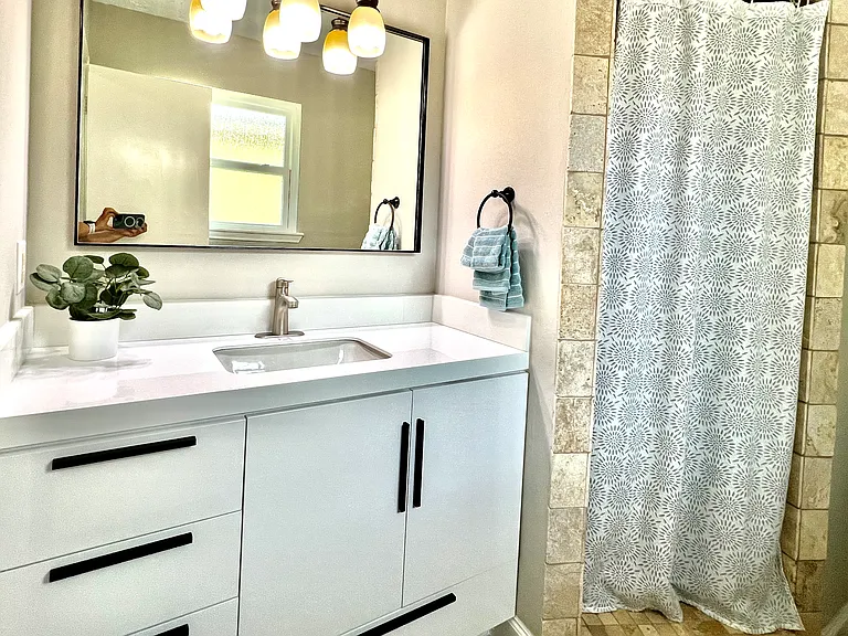 Remodeled master ensuite with a sleek modern vanity, stylish mirror, and fresh, contemporary paint_offering a clean and elegant feel.