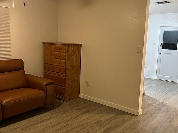 Partial view of living room with hallway leading to the kitchen/dining area. Old photo prior to tile installation. Furniture not included.