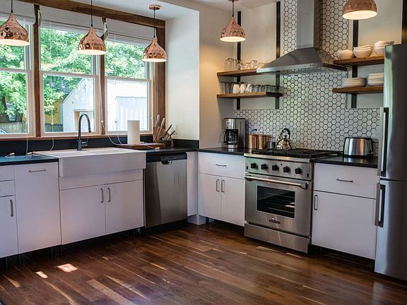 Kitchen with modern amenities: oven, dishwasher, microwave (out of picture at bar sink). The kitchen is fully stocked with tools, pots/pans and accessories.
