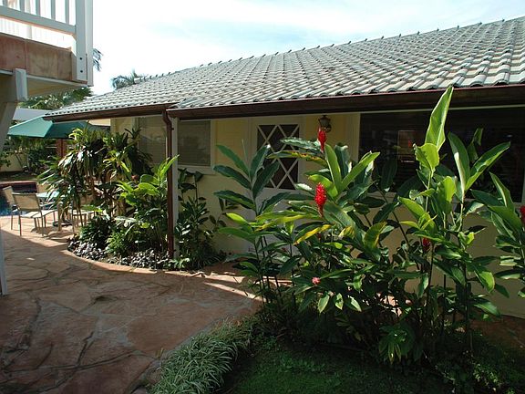 Front of cottage with lush landscaping.