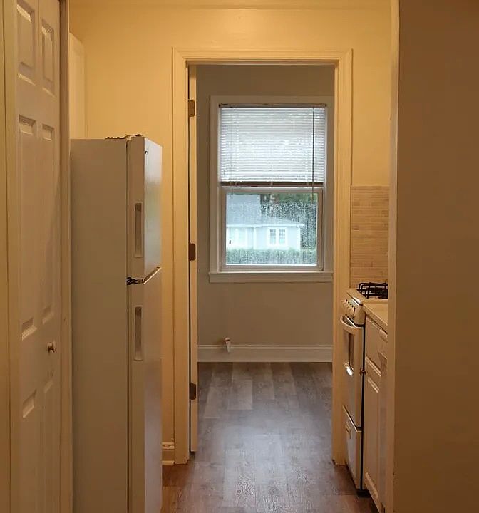 Kitchen: equipped with overhead kitchen cabinets on both sides. On the left: spacious fridge and area for kitchen tech. On the right: dishwasher, stove with oven, big microwave, cooking vent, sink, cooking area.