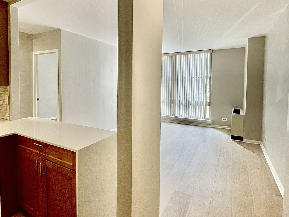 Another broad view of kitchen entry and living area; view to bedroom entry. Wide plank hardwood floors.