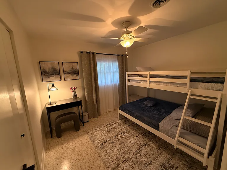 Third bedroom with bunk beds, desk and closet.