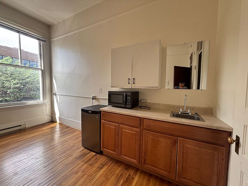 Kitchenette with mini fridge, microwave, storage, and sink.