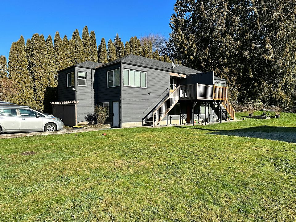 facade showing deck, parking and lawn