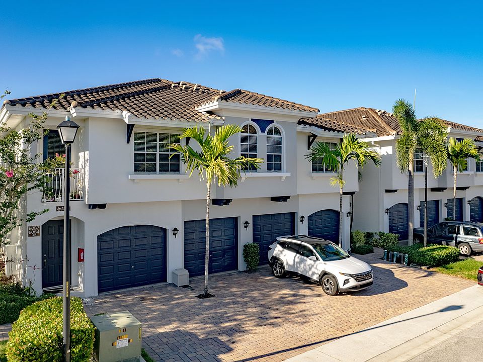 Spacious townhomes with attached garages in a peaceful, palm-lined community.